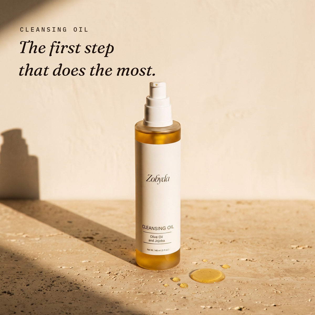 Zobyda Cleansing Oil 140ml bottle on travertine in warm afternoon sunlight