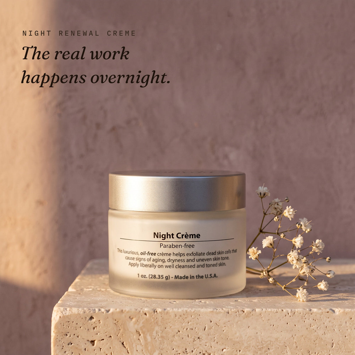 Zobyda Night Renewal Creme 1 oz jar on travertine against a dusty mauve wall