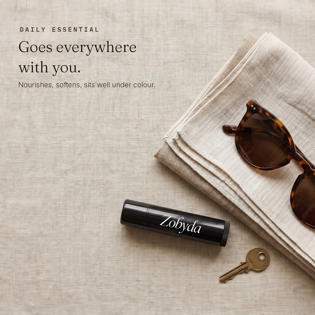 Zobyda Vegan Lip Balm in a bag with a linen scarf, sunglasses and a key
