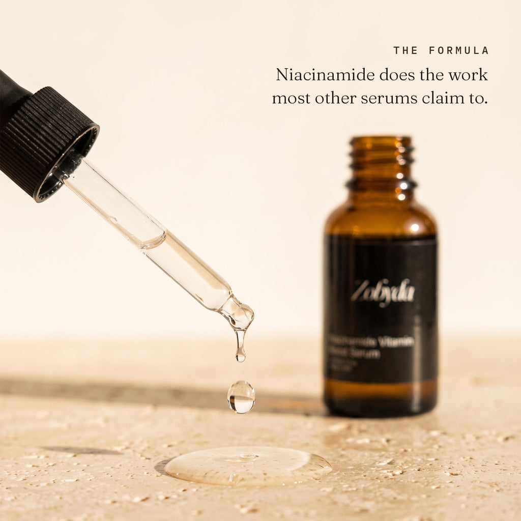 A drop of Zobyda Niacinamide Vitamin Boost Serum falling from the glass dropper beside the bottle