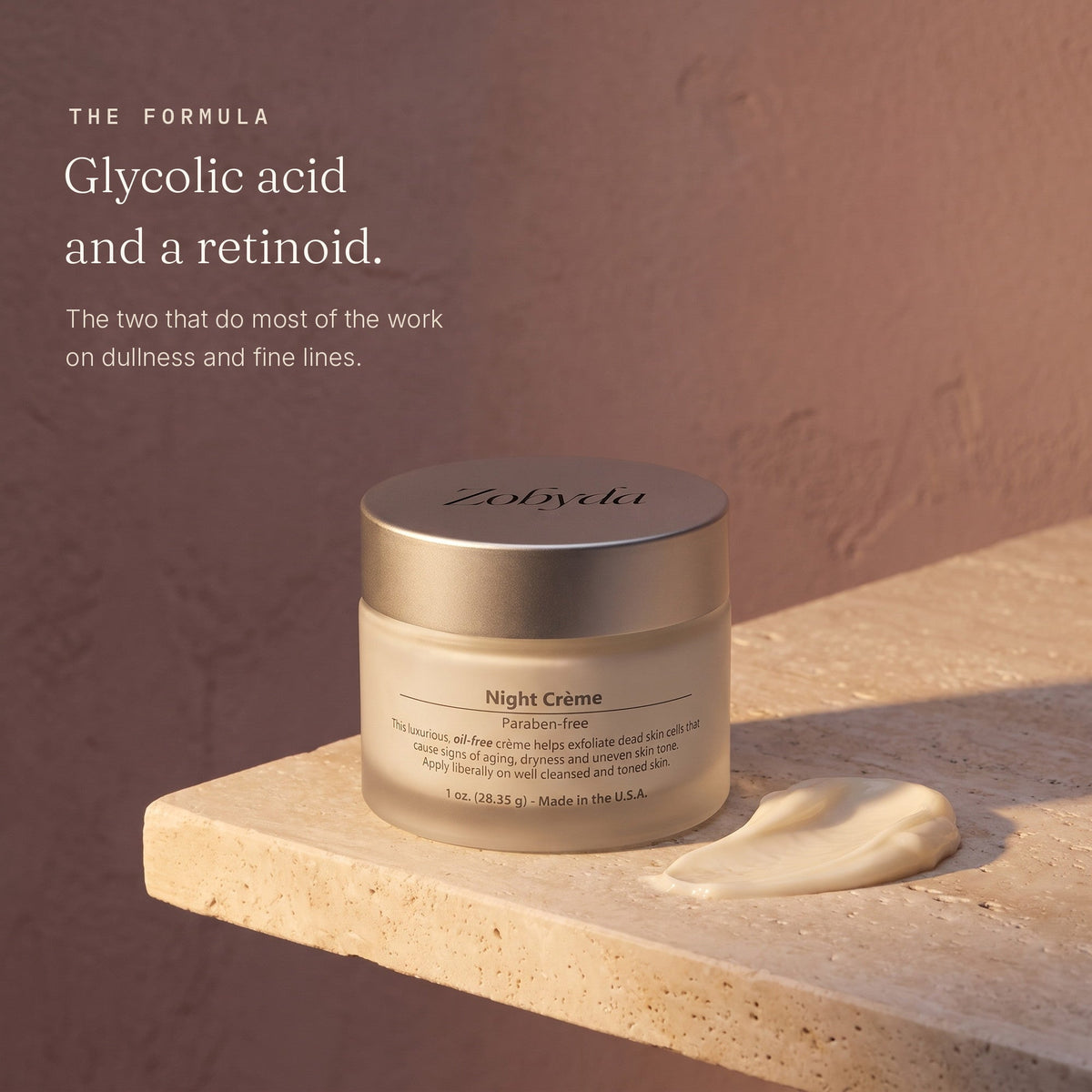 Zobyda Night Renewal Creme jar on travertine with a swirl of the creme, built on glycolic acid and a retinoid