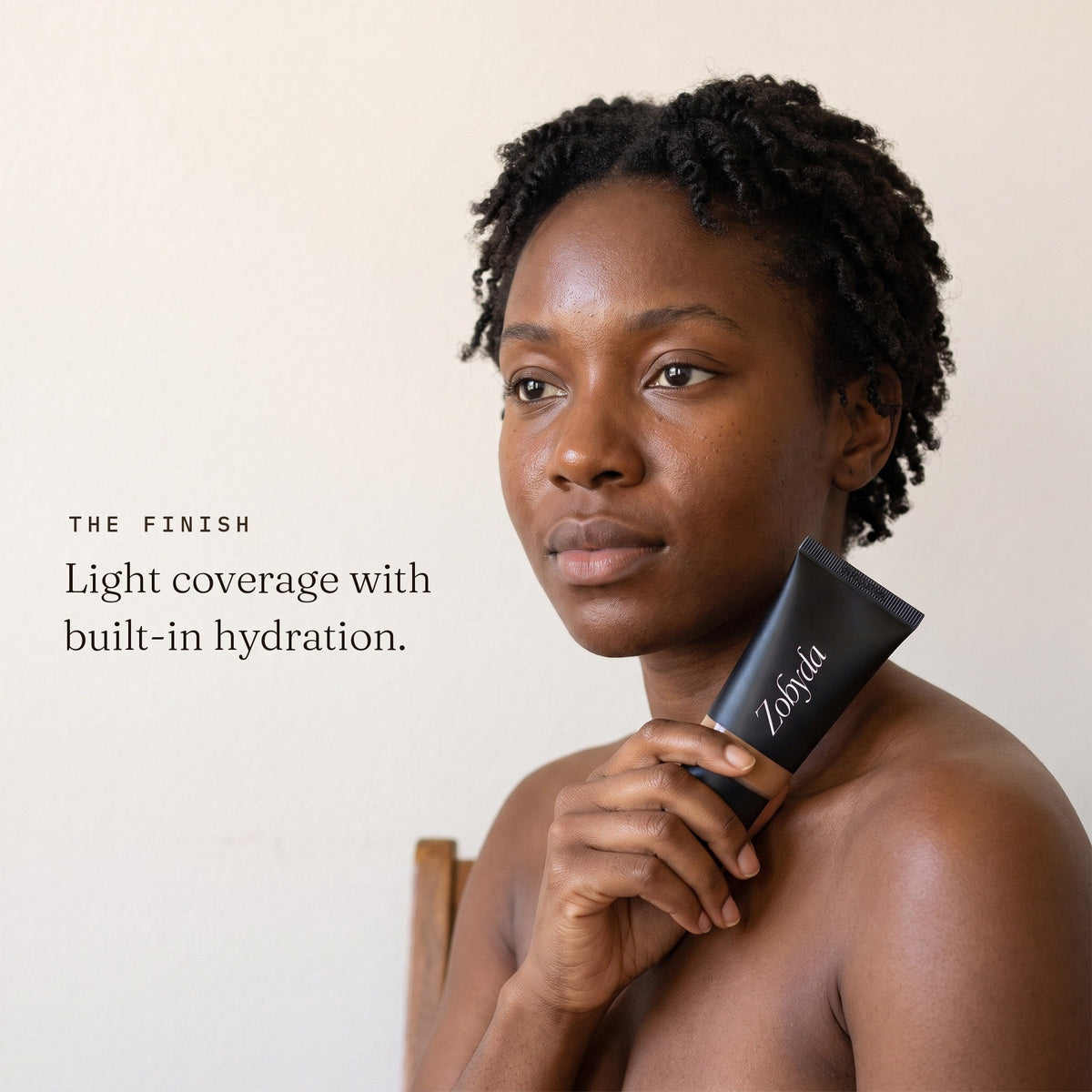 Woman holding Zobyda Tinted Moisturizer: light coverage with built-in hydration
